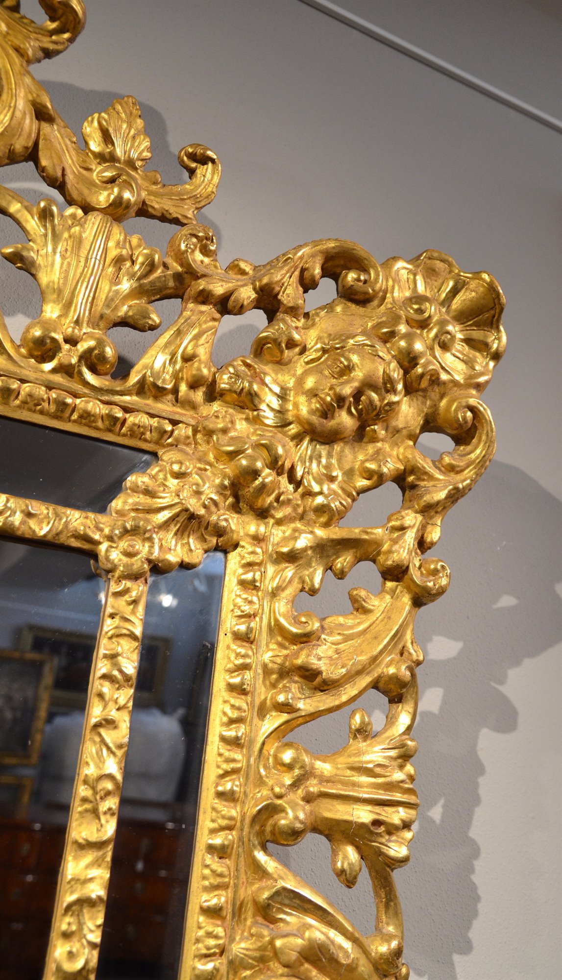 Prestigiosa specchiera, di dimensioni importanti,  in legno intagliato e dorato